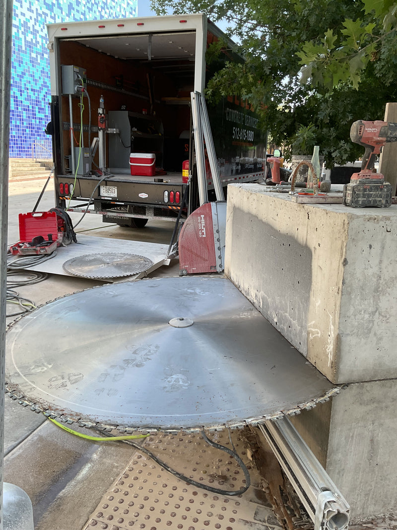 Giant saw cutting into a block of concrete 
