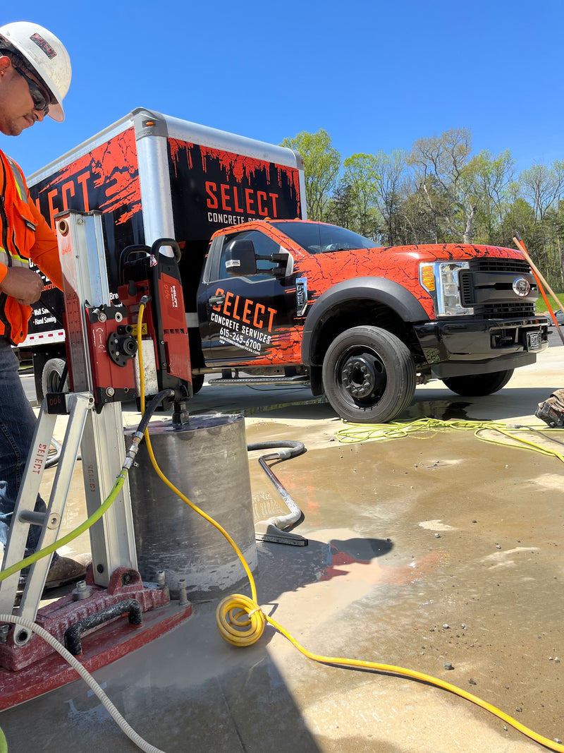 Select concrete worker with a company truck in the background